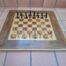 A Wooden Chess Set Comprising Chess Pieces And A Chess Board