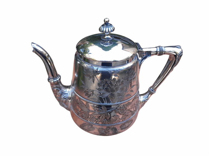 A Silver-Plated Tea Pot With Floral Designs
