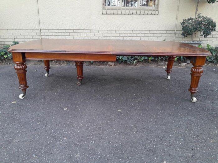 An Antique Victorian Oak Dining Table on Porcelain Castors with Two Leaves (10 Seater) - Image 2