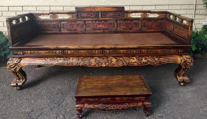 A late 19th Century Chinese Opium Bed in Elm with inlaid detail with small table/foot rest