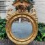 A circular framed 19thC style mirror with eagle crest