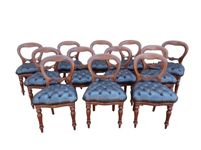 A 20TH Century Set of Twelve Victorian Style Mahogany Bustle Back Dining Chairs Upholstered in Deep Buttoned Leather