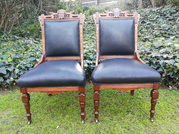 A Late 19th Century Pair of Victorian Carved Walnut Chairs Upholstered in Leather on Casters - Image 2