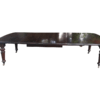 A three meter Victorian mahogany extending dining table on carved legs and castors, with four leaves and crank