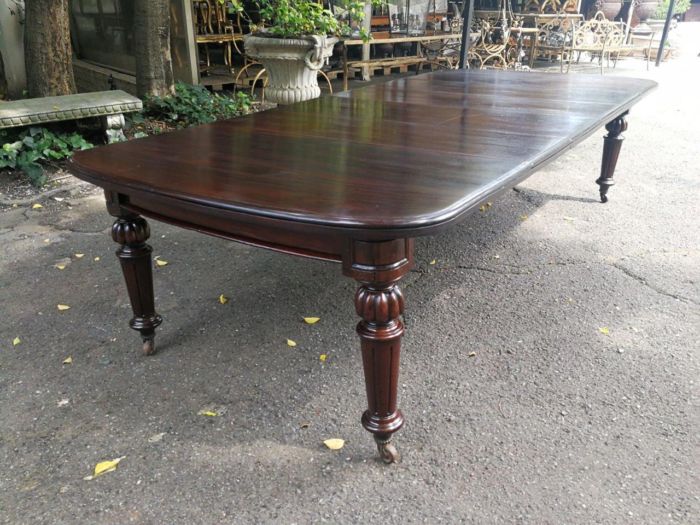 A three meter Victorian mahogany extending dining table on carved legs and castors, with four leaves and crank - Image 4