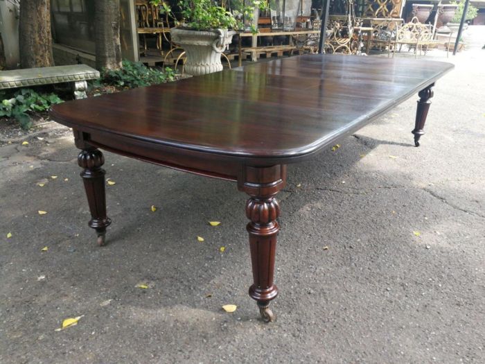 A three meter Victorian mahogany extending dining table on carved legs and castors, with four leaves and crank - Image 5