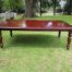 A Victorian mahogany extending ten-seater dining room table on brass castors and with winding crank