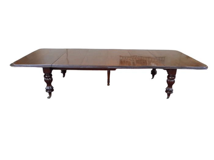 A Massive and Rare Victorian Mahogany Dining / Boardroom Extension table with Four Extensions and Fifth Supporting Leg in the Middle on Original Brass Castors