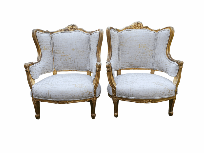 A Pair Of 20th Century French Style Gilt Bergere Armchairs Upholstered In A Custom-Made Hand Printed Linen With Gold Script Design By The Crown Collection
