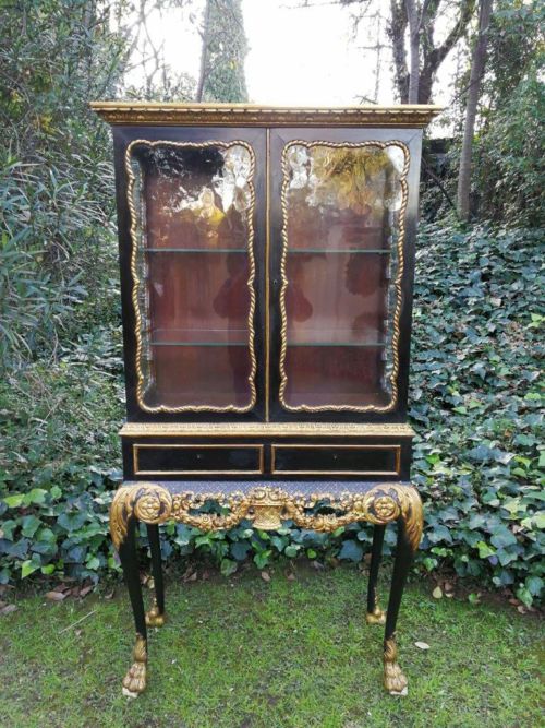 A Victorian-style Painted and Gilded Cabinet/ Display Cabinet with Carved Glazed Doors with Two Drawers Standing On a floral Carved Base with Lion  Paw Feet