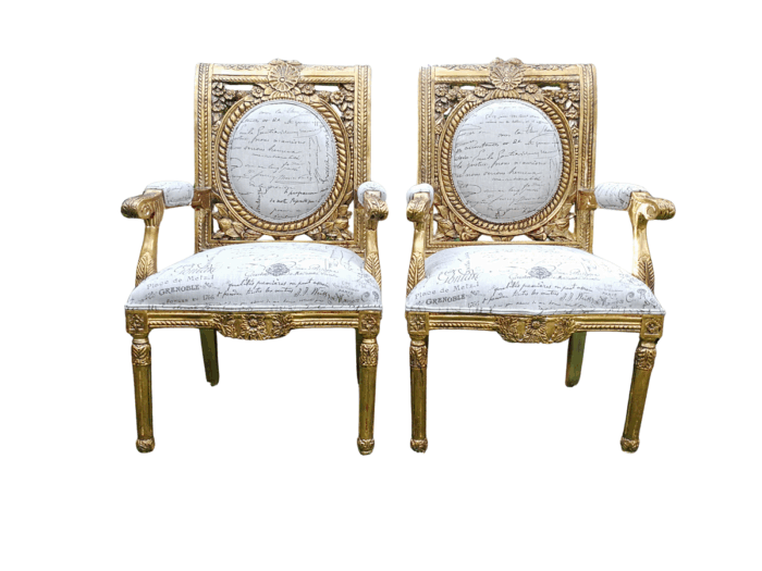 A 20TH Century Pair Of Ornately Carved And Hand Gilded French Style Armchairs Upholstered in a Custom-made for The Crown Collection Script Design Linen ND