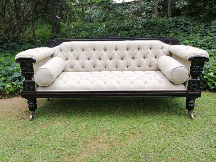 A 20thcentury English Rosewood Settee On Castors And Upholstered In Black Leather And Deep Buttoned 