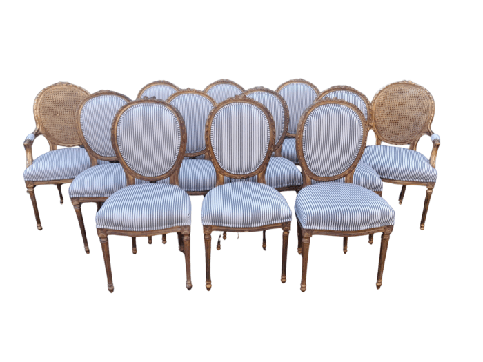 A 20th Century French Style Imported Set Of Twelve Gilded Dining Chairs Comprising: Two Carvers  /  Armchairs With Rattan Backs And Ten Dining Chairs