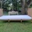 A French Style Hand Gilded Rattan Day Bed Upholstered In A White French Linen With Four Large Size Scatter Cushions