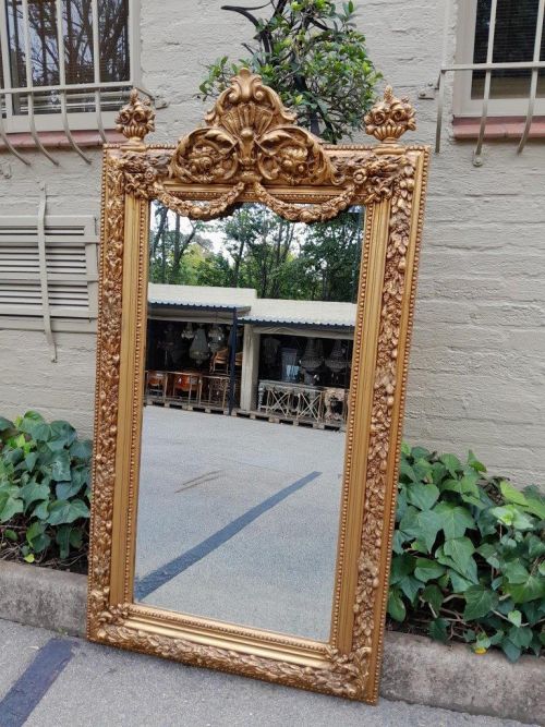A French Style Ornately Carved And Gilded Bevelled Mirror