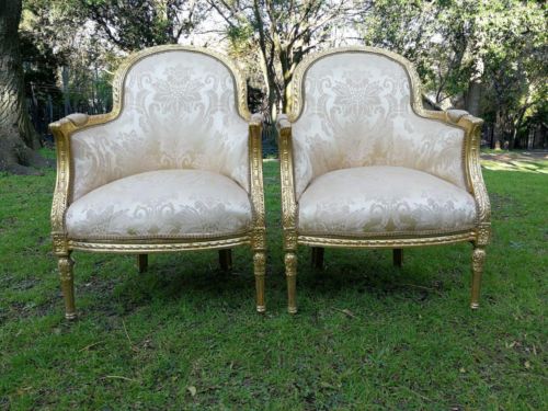 A Pair of French Louis XVI  Style Ornately Carved and Gilded Armchairs