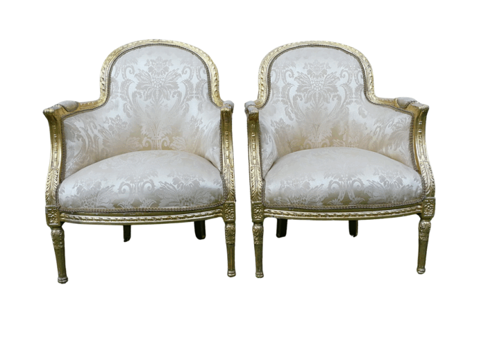 A Pair of French Louis XVI  Style Ornately Carved and Gilded Armchairs