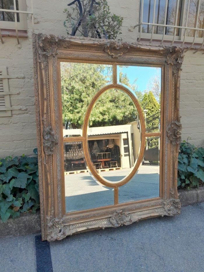 A Large and Heavily Carved Giltwood Bevelled Mirror