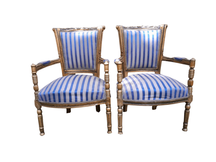 A Pair Of 20th Century French Louis XVI Styled Ornately Carved And Gilded Arm Chairs