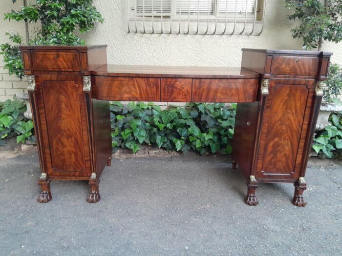 A George III Circa 1820 Mahogany / Flame Mahogany With Parcel Gild Sideboard With Two Cellarette And Lock And Key To Each Cabinet Dimensions: 112cmh X