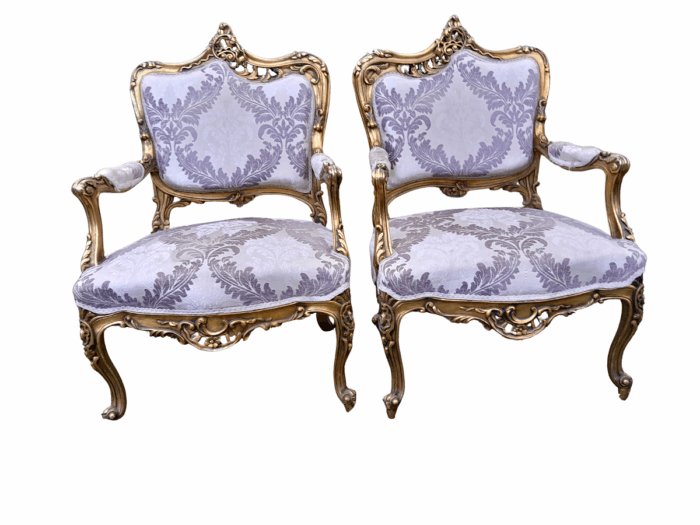 A 20th Century Pair Of French Rococo Style Ornately Carved Wooden Gilt-Wood Arm Chairs