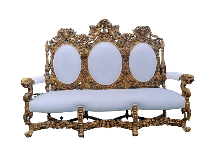 A 19th Century Ornately Carved Walnut Wood Settee Hand Gilded With Gold Leaf And Upholstered In A Linen Fabric