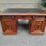 An Edwardian Circa 1910 Oak And Ebonised Desk With Gilt Tooled Green Leather Top Above Three Drawers Inside The Doors