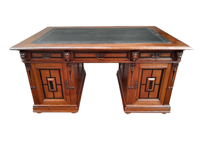 An Edwardian Circa 1910 Oak And Ebonised Desk With Gilt Tooled Green Leather Top Above Three Drawers Inside The Doors