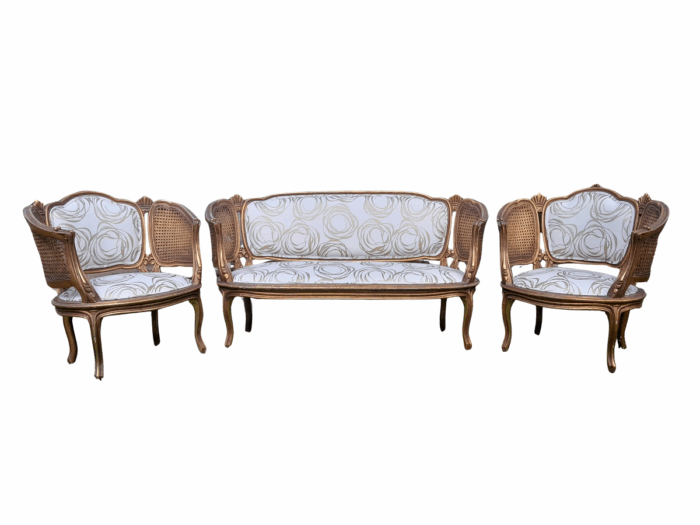 A Mid 20th Century Circa 1950 French Set Of Gilt Painted Wooden And Rattan Settee With A Pair Of Bergère Chairs Upholstered In A Custom Made Linen For The Crown Collection