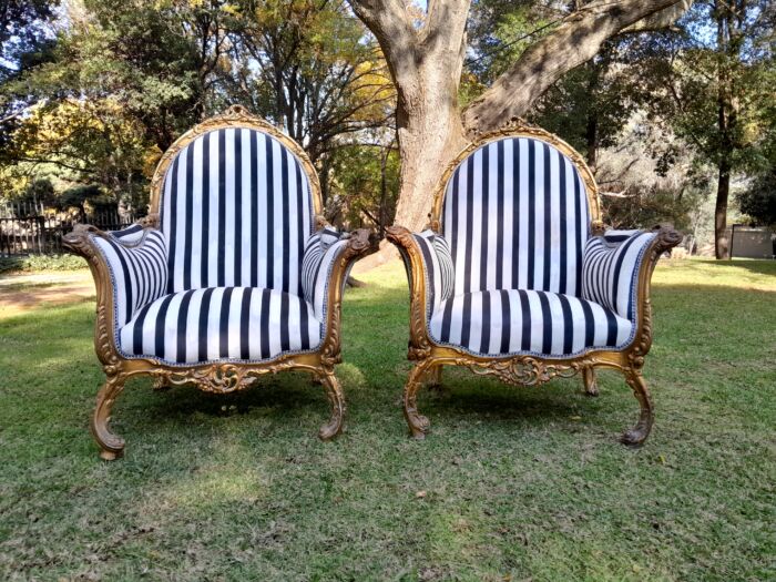 A 20th Century Pair of French Style Louis XVI Style Ornately Carved and Gilded Armchairs - Image 2