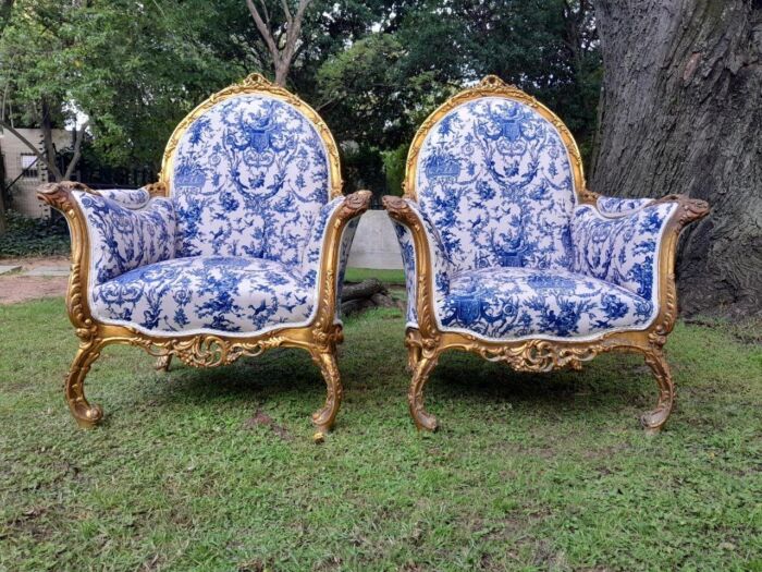 A 20th Century Pair of French Style Louis XVI Style Ornately Carved and Gilded Armchairs