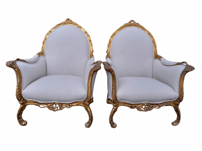 A 20th Century Pair of French Style Louis XVI Style Ornately Carved and Gilded Armchairs