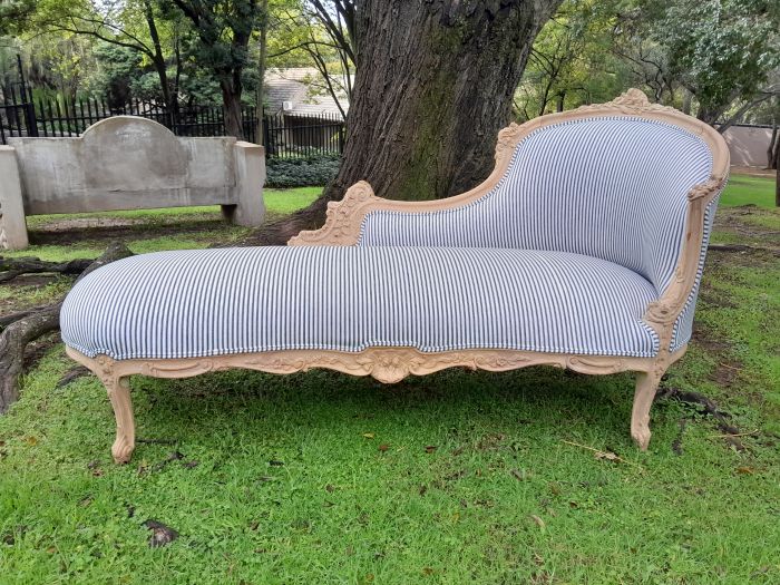 A 20th Century French Style Ornately Carved Chaise Longue in a Contemporary Bleached Finish and Upholstered in Ticking Fabric - Image 2