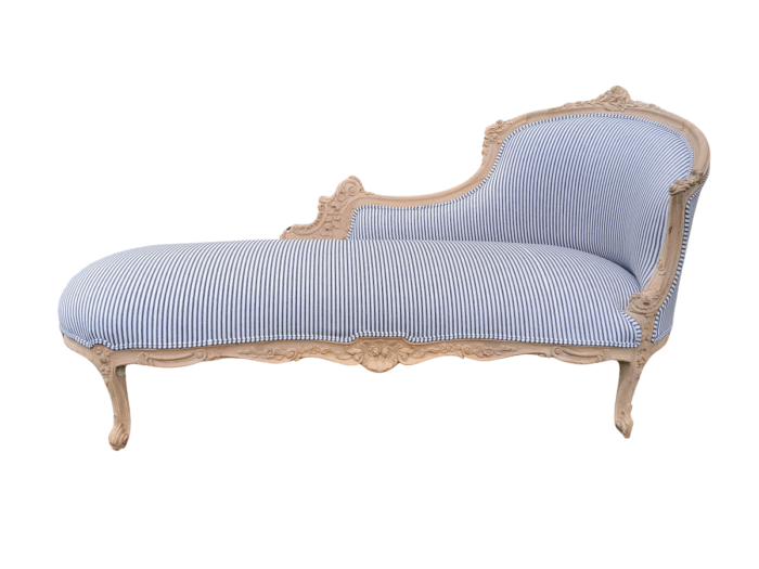 A 20th Century French Style Ornately Carved Chaise Longue in a Contemporary Bleached Finish and Upholstered in Ticking Fabric
