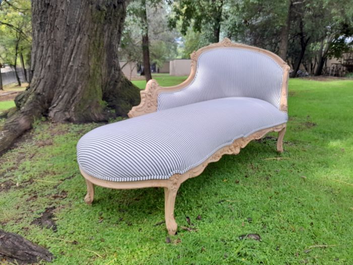 A 20th Century French Style Ornately Carved Chaise Longue in a Contemporary Bleached Finish and Upholstered in Ticking Fabric - Image 4