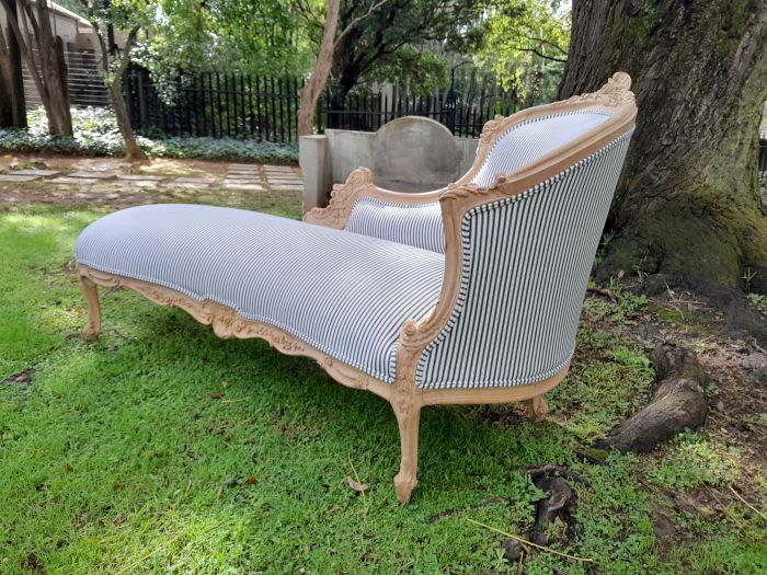 A 20th Century French Style Ornately Carved Chaise Longue in a Contemporary Bleached Finish and Upholstered in Ticking Fabric - Image 5
