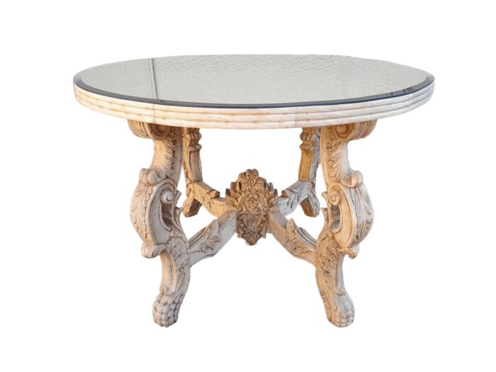 A 20th Century Ornately Carved Circular Wooden Table In A Contemporary Bleached Finish And With A Bevelled Mirror Top