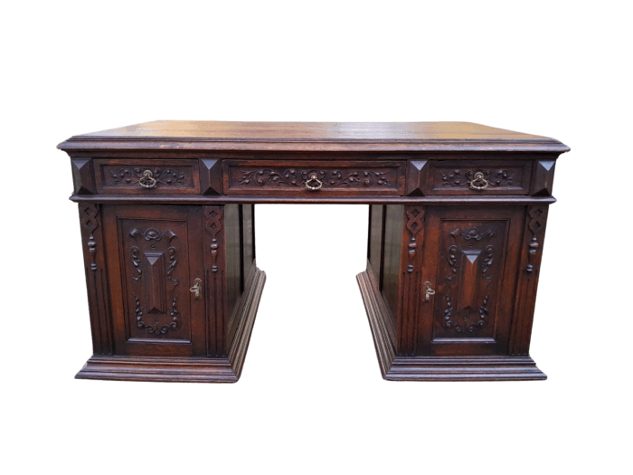 A 20th Century Ornately Carved Oak Pedestal Desk with Drawers