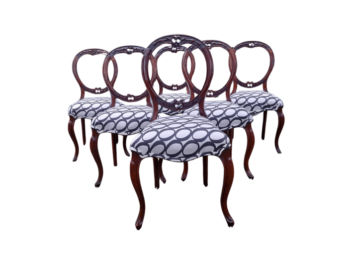 An Antique Victorian Walnut Set of Six Ornately Carved Chairs