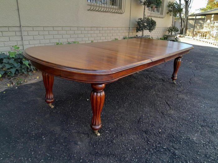 A Massive Antique Circa 1880 Victorian Carved Mahogany Dining Table With Two Extensions On Castors And With Crank Handle - Image 5