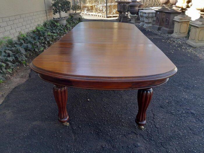 A Massive Antique Circa 1880 Victorian Carved Mahogany Dining Table With Two Extensions On Castors And With Crank Handle - Image 6