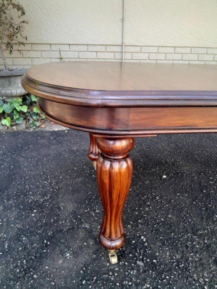 A Massive Antique Circa 1880 Victorian Carved Mahogany Dining Table With Two Extensions On Castors And With Crank Handle - Image 8