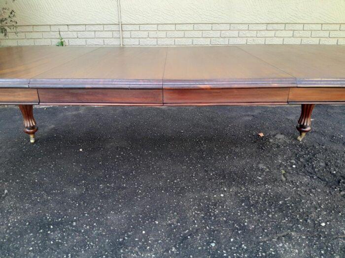 A Massive Antique Circa 1880 Victorian Carved Mahogany Dining Table With Two Extensions On Castors And With Crank Handle - Image 9