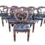 A 20th Century Set Of Twelve Teak Wood Bustle Back Chairs Comprising A Pair Of Carvers / Armchairs And Ten Dining Chairs Upholstered In Deep Buttoned Leather  