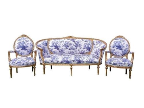 A French Style Ornately Carved Giltwood Settee With A Pair Of Armchairs Upholstered In A French Blue And White Toile Fabric