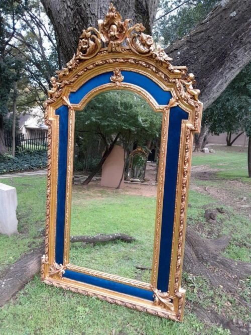 An Ornate Rococo Style Carved Giltwood And Bevelled Mirror With Royal Blue Suede Inner Lining