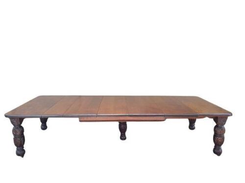 A 19th Century English Oak Large Dining Table With Five Heavily Carved Legs And Extensions On Original Castors