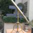 An Antique Brass Floor Standing Telescope On Tripod With Lens Cover
