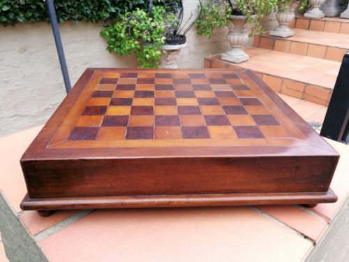 An Antique  Early 20th Century Circa 1910 Walnut And Mahogany Chess/Games Board On Feet With A Storage Compartment