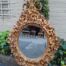 A 20th Century Baroque Style Heavily Carved And Ornate Gilt-Framed Bevelled Glass Mirror